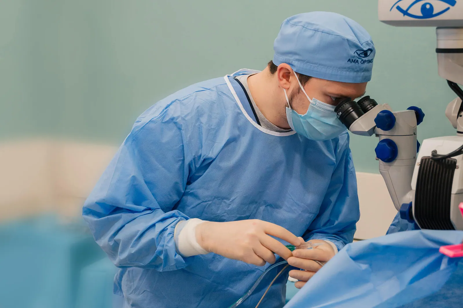 Chirurg oftalmolog operând la microscop în sala de operații